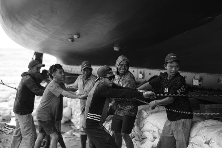 Para panrita Lopi yang sedang menarik takal untuk peluncuran kapal pinisi